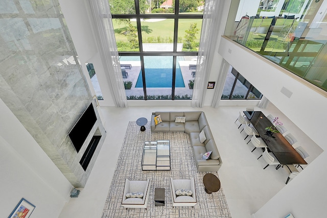 living room with tile floors, tile walls, and a high ceiling