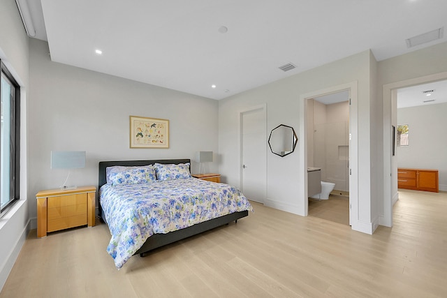 bedroom featuring light wood-type flooring and ensuite bathroom