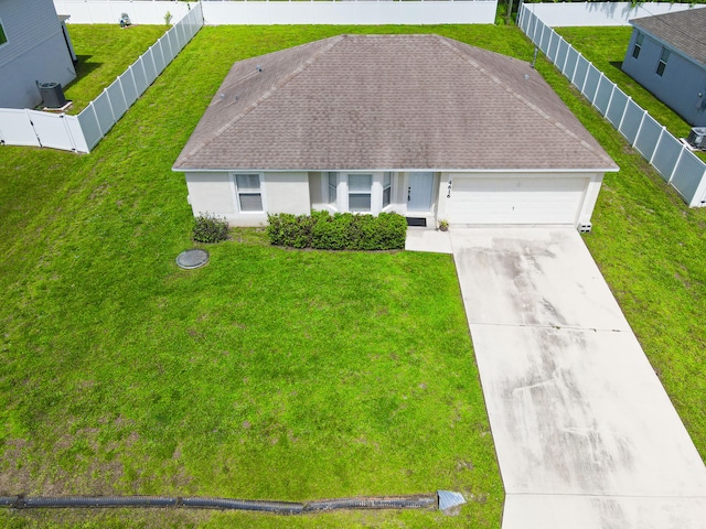 view of front of home featuring a garage, central AC, and a front lawn