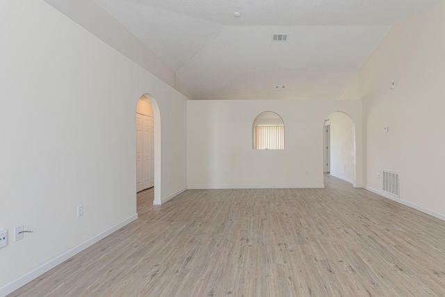 empty room with wood-type flooring and lofted ceiling