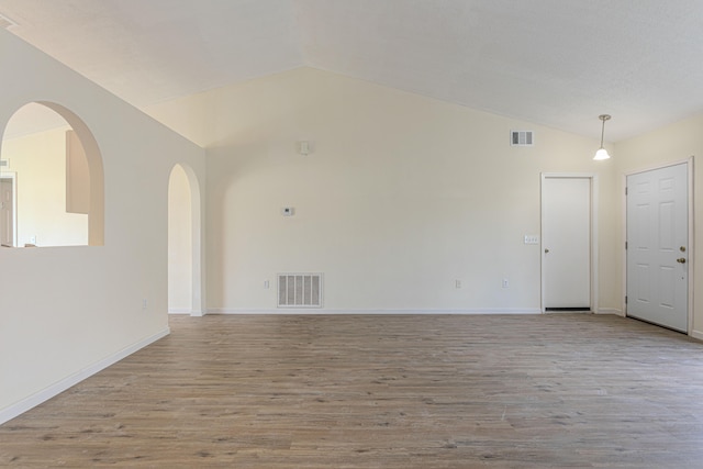 empty room featuring vaulted ceiling and light wood-type flooring