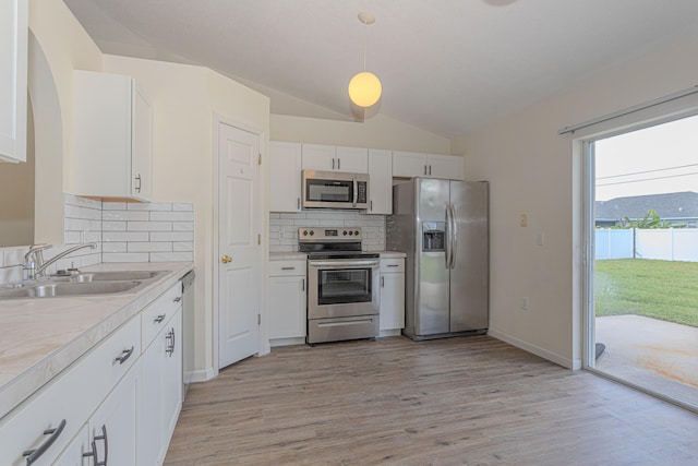 kitchen with hanging light fixtures, decorative backsplash, light hardwood / wood-style flooring, and stainless steel appliances