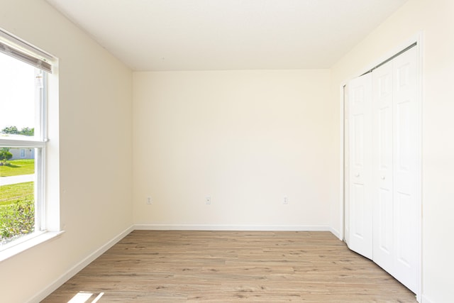 unfurnished bedroom with a closet and light wood-type flooring