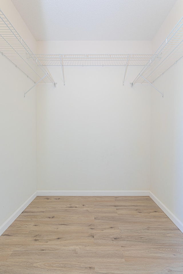 unfurnished bedroom featuring light hardwood / wood-style floors and lofted ceiling