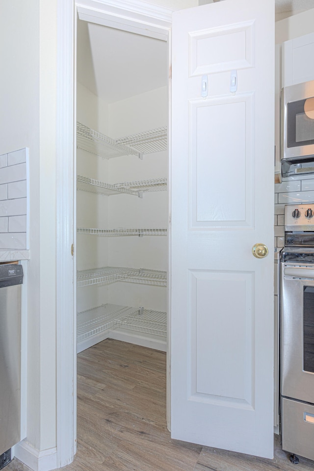 laundry room featuring hookup for a washing machine, electric dryer hookup, and hardwood / wood-style floors