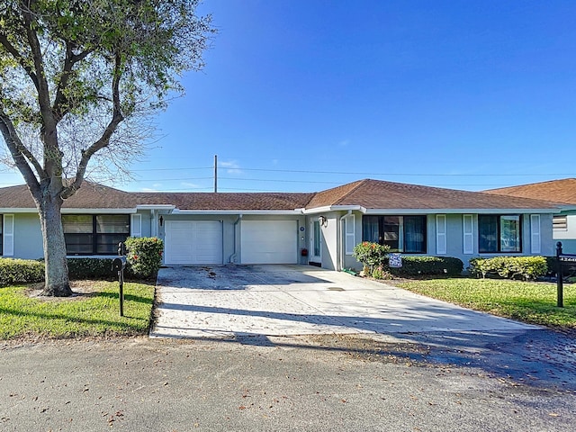 ranch-style home featuring a garage, concrete driveway, a front lawn, and stucco siding