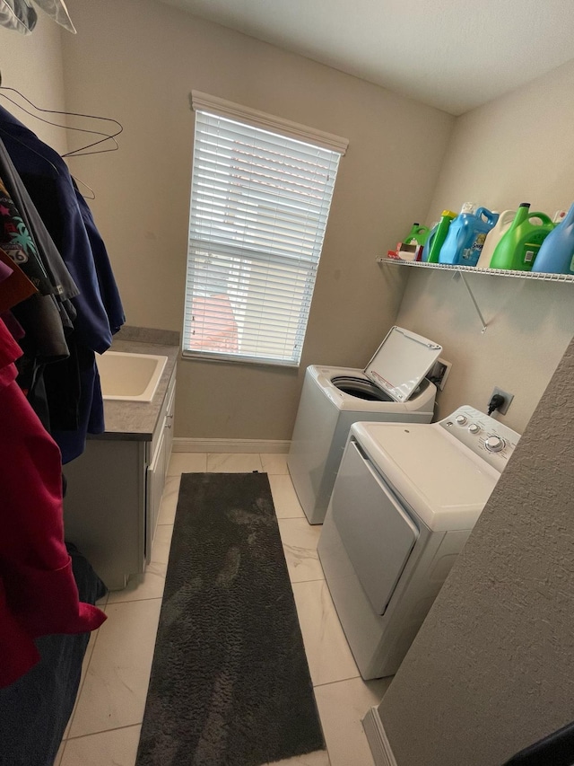 laundry area featuring light tile floors, sink, and independent washer and dryer