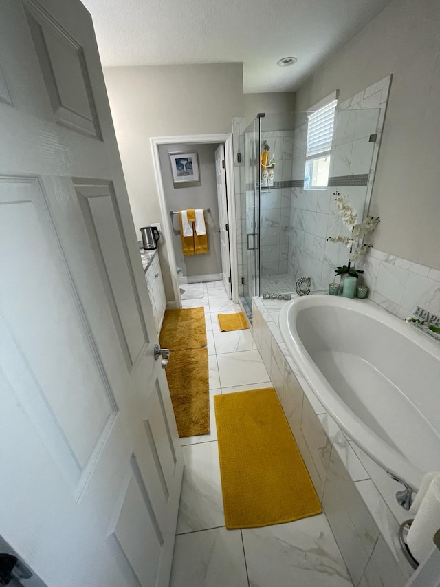 bathroom featuring tile flooring and separate shower and tub