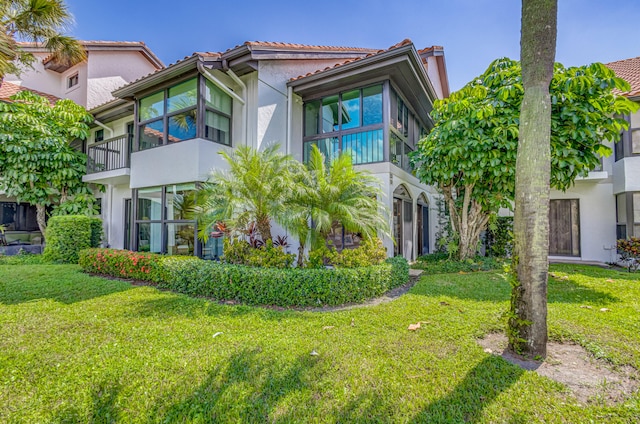 view of front of property with a balcony and a front yard