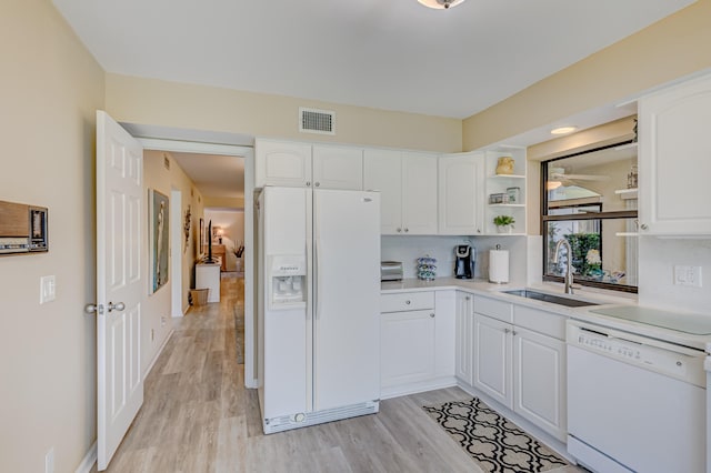 kitchen with light hardwood / wood-style flooring, sink, white appliances, and white cabinetry