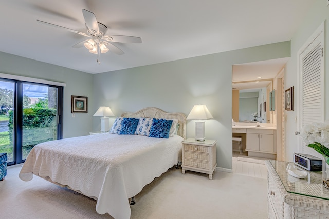 bedroom featuring ceiling fan, light colored carpet, access to outside, and ensuite bathroom