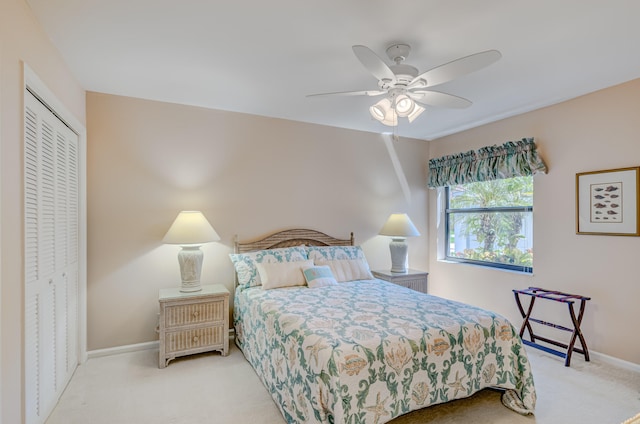 bedroom featuring ceiling fan, light carpet, and a closet