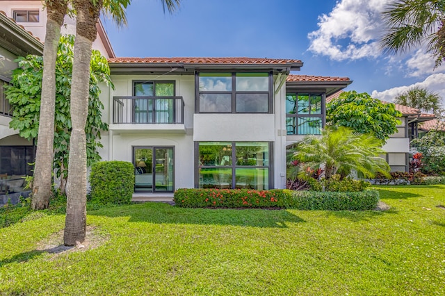 view of front of home with a balcony and a front yard