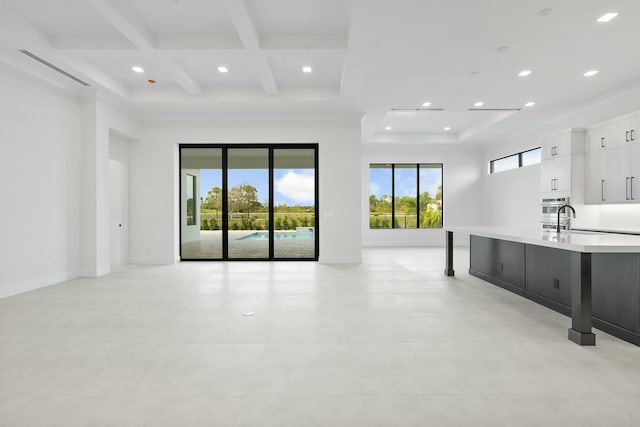 spare room featuring beamed ceiling, coffered ceiling, and sink