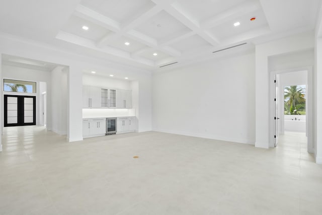 unfurnished living room featuring a healthy amount of sunlight, beam ceiling, wine cooler, and coffered ceiling