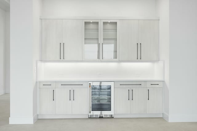 bar with beverage cooler and light tile patterned flooring