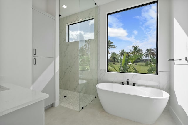 bathroom with tile patterned floors, vanity, and separate shower and tub