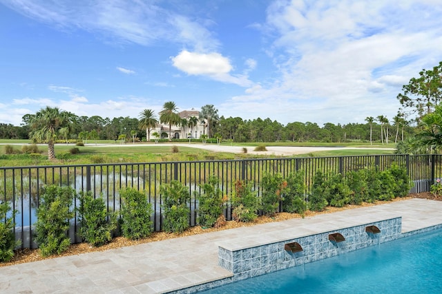 view of swimming pool with pool water feature and a water view