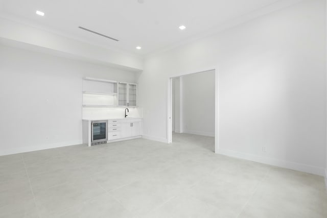 unfurnished living room featuring ornamental molding, wine cooler, indoor wet bar, and light tile patterned flooring