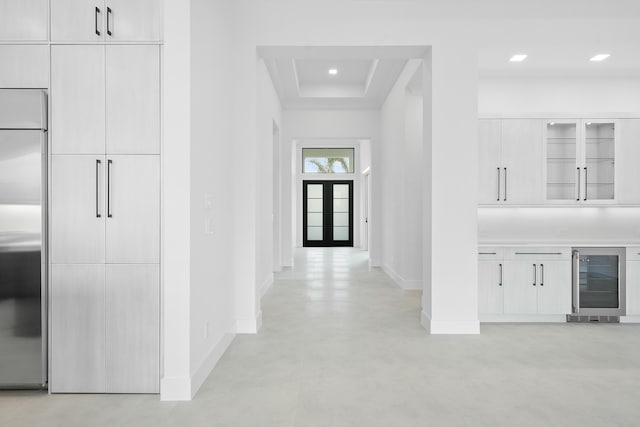 hall with a tray ceiling and wine cooler