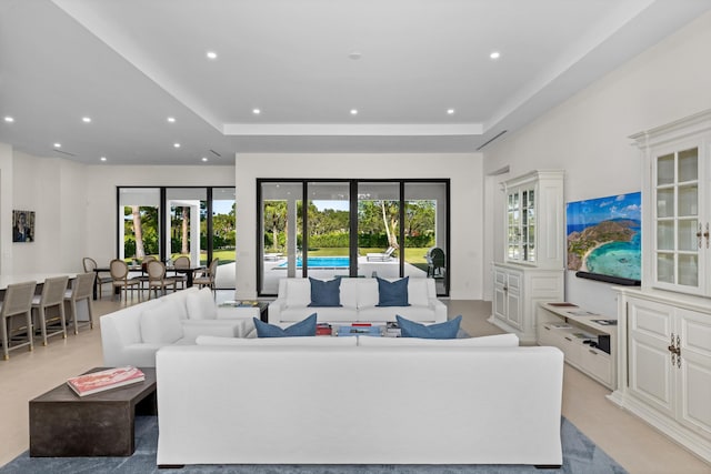 living room featuring a tray ceiling and a wealth of natural light