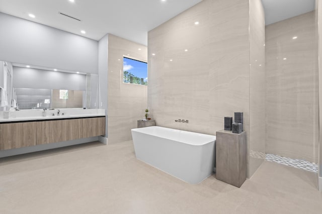 bathroom featuring vanity, separate shower and tub, and tile walls