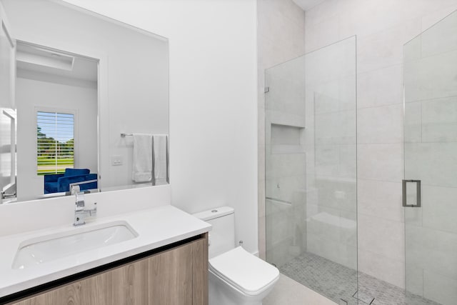 bathroom featuring vanity, toilet, and a shower with shower door