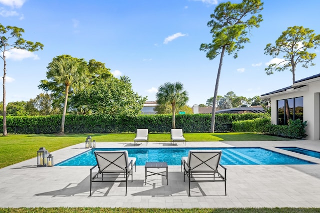 view of pool with a patio area and a yard