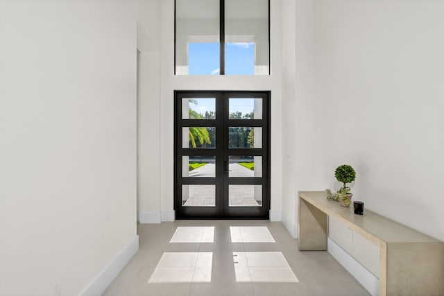 tiled foyer entrance with a towering ceiling and built in desk