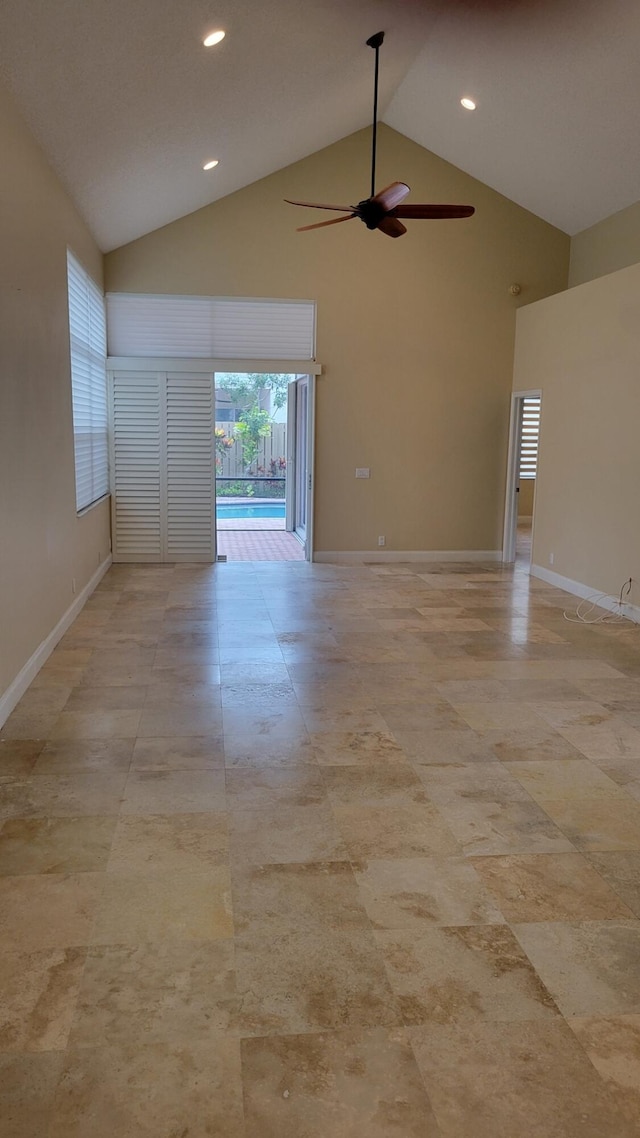 spare room featuring high vaulted ceiling and ceiling fan