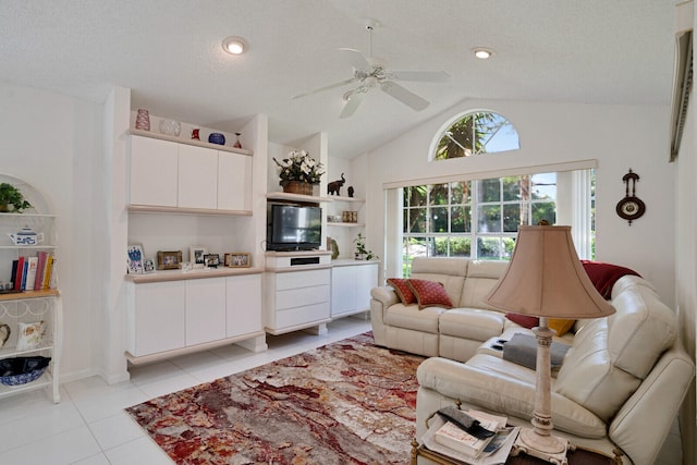 living room with a textured ceiling, ceiling fan, and light tile floors