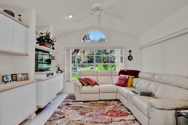 living room featuring plenty of natural light, vaulted ceiling, ceiling fan, and light tile flooring