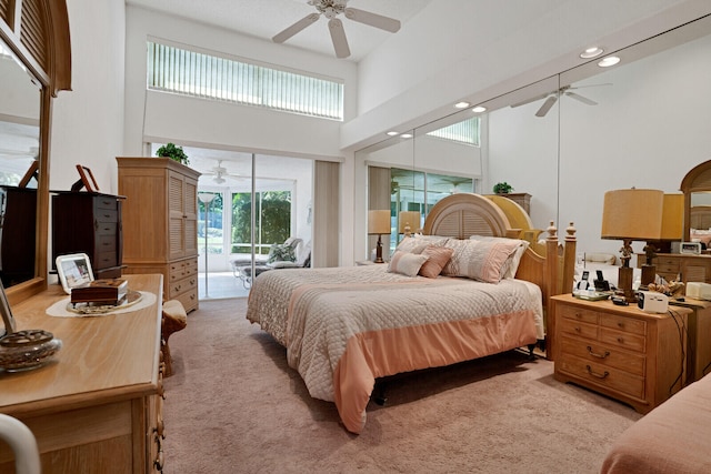 bedroom with access to outside, ceiling fan, a towering ceiling, and light colored carpet