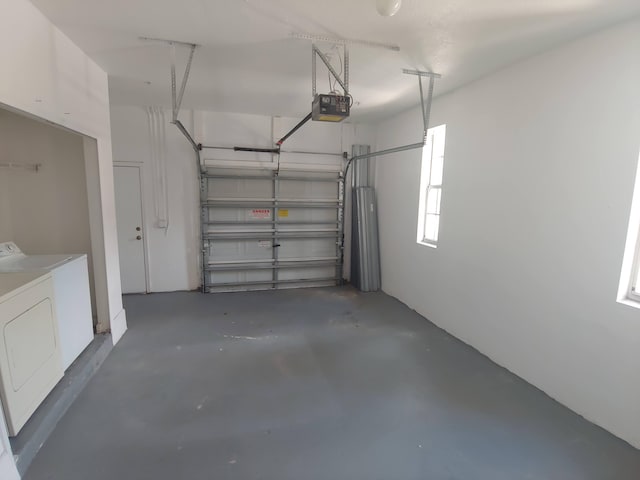 garage with independent washer and dryer and a garage door opener