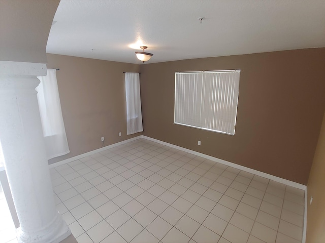 tiled spare room featuring ornate columns