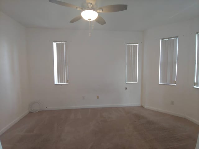 carpeted empty room featuring ceiling fan