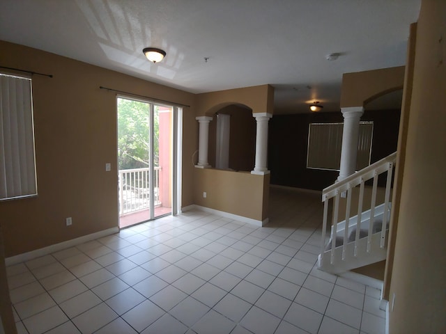 tiled empty room featuring decorative columns