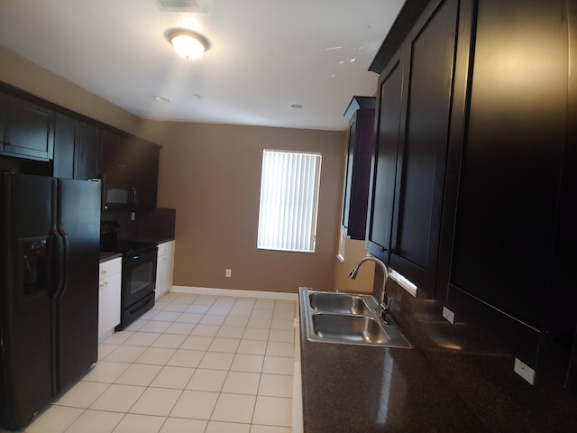 kitchen with sink, light tile floors, range with electric stovetop, and black fridge