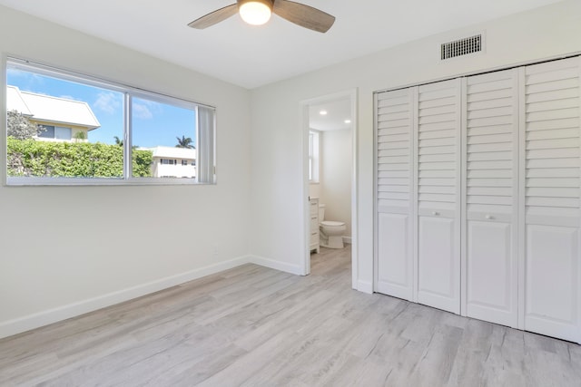 unfurnished bedroom featuring visible vents, light wood-style floors, baseboards, a closet, and ensuite bath