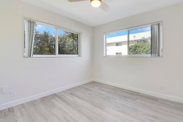 spare room with light wood finished floors, ceiling fan, and baseboards