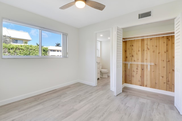 unfurnished bedroom featuring baseboards, visible vents, a ceiling fan, connected bathroom, and light wood-style floors