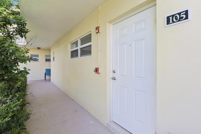 doorway to property featuring stucco siding