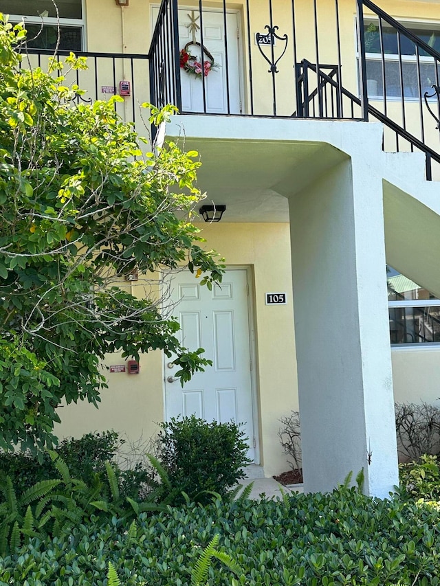 entrance to property with a garage and stucco siding