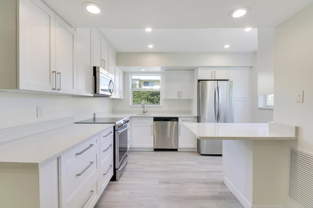 kitchen with light stone counters, stainless steel appliances, visible vents, white cabinets, and a sink