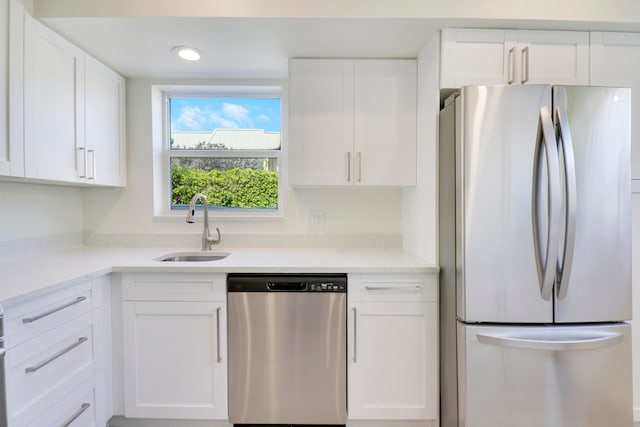 kitchen featuring appliances with stainless steel finishes, white cabinets, and a sink