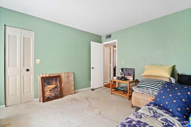 carpeted bedroom with a textured ceiling and a closet