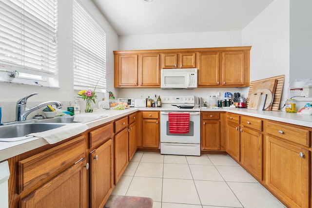 kitchen featuring white appliances, sink, and light tile floors