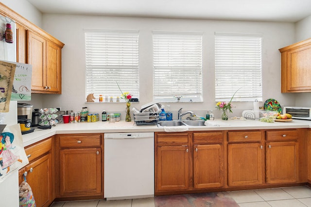 kitchen featuring white dishwasher, light tile floors, and sink