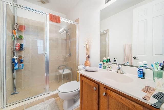 bathroom featuring toilet, vanity, and a shower with shower door