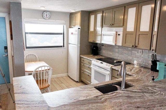 kitchen featuring light stone countertops, white appliances, sink, light hardwood / wood-style flooring, and tasteful backsplash